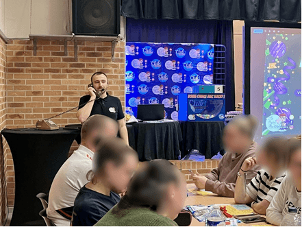 L’animateur du Loto des Boîtes au micro devant les participants