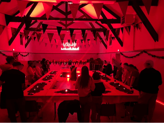 La salle de La Nuit des Loups, avec ses tables de jeu et sa mise en lumière rouge
